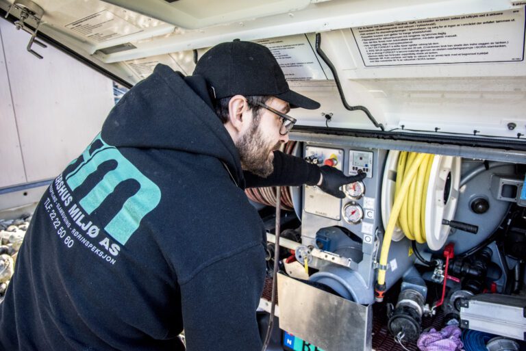 bildet viser ansatt i Akershus Miljø AS inne i en firmabil på oppdrag.